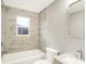 Bright bathroom featuring a shower-tub combo with modern tile and fixtures, and a large mirror at 6104 Gifford St, Indianapolis, IN 46228