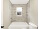Bathroom featuring tile, shower-tub combo with modern fixtures, and toilet at 6104 Gifford St, Indianapolis, IN 46228