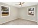 Sun-filled bedroom with carpet flooring, two windows, and neutral paint at 6104 Gifford St, Indianapolis, IN 46228