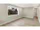 Open-concept living area showcasing hardwood floors, neutral walls, and ample natural light from large window at 6104 Gifford St, Indianapolis, IN 46228