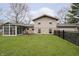 Home backyard with a well-maintained lawn, a sunroom, and fencing at 647 Mulford Ct, Indianapolis, IN 46234