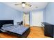 This bedroom features a ceiling fan, hardwood floors, and light blue walls at 647 Mulford Ct, Indianapolis, IN 46234