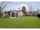 Home exterior view showcasing the sunroom, stone accents, and expansive backyard at 647 Mulford Ct, Indianapolis, IN 46234