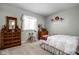 Bright bedroom with a window, carpeted floor, dresser, and shelf for decorative items at 649 Hummingbird Dr, Brownsburg, IN 46112