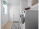 Well-lit laundry room with white washer and dryer, tile flooring, and window providing natural light at 649 Hummingbird Dr, Brownsburg, IN 46112