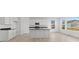 Open-concept kitchen boasts an island, white cabinets, black countertops, and stainless steel appliances at 6890 Enclave Dr, McCordsville, IN 46055