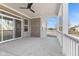 Covered patio with brick accents, white railings, a ceiling fan, and a sliding glass door leading inside at 6890 Enclave Dr, McCordsville, IN 46055