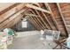 Unfinished attic space with exposed wooden beams and a small window, offering potential for customization at 83 W Garfield Ave, Martinsville, IN 46151
