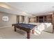 Finished basement featuring a billiards table, comfortable seating, and a built-in media center for entertainment at 9914 Springstone Rd, Fishers, IN 46055