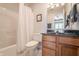 Bathroom featuring a shower-tub combo, a wooden vanity with a granite countertop, and a large mirror at 9914 Springstone Rd, Fishers, IN 46055