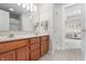 Bright bathroom featuring double vanity, wood cabinets, a large mirror and tile flooring at 9914 Springstone Rd, Fishers, IN 46055