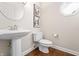 Elegant powder room with pedestal sink, modern fixtures, and stylish artwork at 9914 Springstone Rd, Fishers, IN 46055