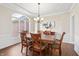 Dining room featuring hardwood floors, wainscoting, a chandelier, and a large window with natural light at 9914 Springstone Rd, Fishers, IN 46055