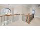 Upstairs hallway with carpet and view to arched window and railing at 9914 Springstone Rd, Fishers, IN 46055
