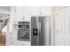 Kitchen featuring stainless steel appliances, white cabinets, quartz countertops, subway tile, and hardwood flooring at 9914 Springstone Rd, Fishers, IN 46055