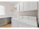 Functional laundry room featuring side-by-side washer and dryer, ample counter space, and storage cabinets at 9914 Springstone Rd, Fishers, IN 46055