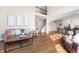 Spacious living room featuring hardwood floors with couch and view to stairs and kitchen at 9914 Springstone Rd, Fishers, IN 46055