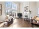 Spacious living room with hardwood floors, a fireplace, large windows, and comfortable seating at 9914 Springstone Rd, Fishers, IN 46055