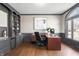 Home office with custom built-ins, a large window, hardwood flooring, and sophisticated decor at 9914 Springstone Rd, Fishers, IN 46055