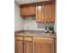 Convenient wet bar featuring wooden cabinetry, a sink, and wine glass storage for easy entertaining at 9914 Springstone Rd, Fishers, IN 46055