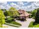 Aerial view of the home showcasing its manicured landscaping and circular driveway surrounded by mature trees at 10541 Titan Run, Carmel, IN 46032
