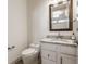 Charming powder room showcasing a granite countertop vanity, decorative mirror, and modern toilet at 10541 Titan Run, Carmel, IN 46032