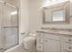 Bright bathroom featuring a glass enclosed shower, toilet, vanity with granite countertops and a decorative framed mirror at 10541 Titan Run, Carmel, IN 46032