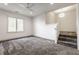Bonus room with plush gray carpet, ample natural light, and stairs to another level at 10541 Titan Run, Carmel, IN 46032