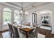 Formal dining room featuring large windows, hardwood floors, and designer lighting fixture at 10541 Titan Run, Carmel, IN 46032