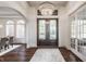 Elegant foyer with hardwood floors, decorative lighting, and a view into the dining room at 10541 Titan Run, Carmel, IN 46032