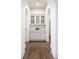 Elegant hallway with hardwood floors, arched doorways, and a stylish built-in white cabinet with glass doors at 10541 Titan Run, Carmel, IN 46032