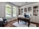 Bright home office with custom built-ins, hardwood flooring, and large windows overlooking the yard at 10541 Titan Run, Carmel, IN 46032