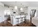 Modern kitchen with stainless steel appliances, white cabinets, breakfast bar, and hardwood floors at 10541 Titan Run, Carmel, IN 46032