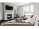 Cozy living room featuring a fireplace, large windows, and a comfortable sectional sofa at 10541 Titan Run, Carmel, IN 46032