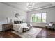 Inviting main bedroom with tray ceiling, hardwood floors, large window, and neutral decor at 10541 Titan Run, Carmel, IN 46032