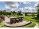 Outdoor kitchen and bar area overlooking lush backyard and pond at 10541 Titan Run, Carmel, IN 46032
