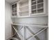 Custom built-in white storage featuring glass-door cabinets and a decorative wine rack below at 10541 Titan Run, Carmel, IN 46032