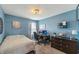 A bedroom with blue walls, a soft patterned comforter, a computer, and a wooden dresser at 10887 Gresham Pl, Noblesville, IN 46060