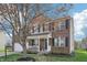 Charming two-story brick home with a well-manicured lawn and covered porch at 10887 Gresham Pl, Noblesville, IN 46060