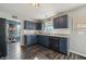 A kitchen with dark blue cabinets, stainless steel appliances, light countertops, and hardwood floors at 10887 Gresham Pl, Noblesville, IN 46060