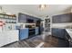 A kitchen with dark blue cabinets and black appliances with an open shelving pantry off to the side at 10887 Gresham Pl, Noblesville, IN 46060