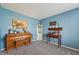 A cozy room with blue walls and carpet, featuring a vintage piano and charming decorative items at 10887 Gresham Pl, Noblesville, IN 46060