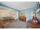 Charming living room with blue walls, a vintage piano, and hardwood floors leading into the dining area at 10887 Gresham Pl, Noblesville, IN 46060