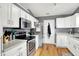 Kitchen with white cabinets, stainless steel appliances, and wood flooring at 12689 Sovereign Ln, Fishers, IN 46038