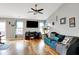 Spacious living room with hardwood floors, a large TV, and lots of natural light at 12689 Sovereign Ln, Fishers, IN 46038