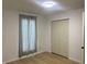 Bright bedroom with new flooring, white walls, a large window and double door closet at 1310 N Lasalle St, Indianapolis, IN 46201