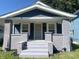 Charming home featuring a covered front porch with decorative columns and freshly painted stairs at 1310 N Lasalle St, Indianapolis, IN 46201