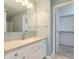 Bright bathroom featuring white vanity and cabinets with large mirror and walk-in closet at 1325 E 47Th St, Anderson, IN 46013