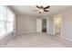 Spacious bedroom with carpet flooring, ceiling fan, and bathroom access at 1325 E 47Th St, Anderson, IN 46013