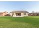 View of the back exterior with a patio overlooking a spacious lawn at 1325 E 47Th St, Anderson, IN 46013